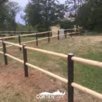 Staccionata in acciaio corten e legno a protezione di un parco giochi
